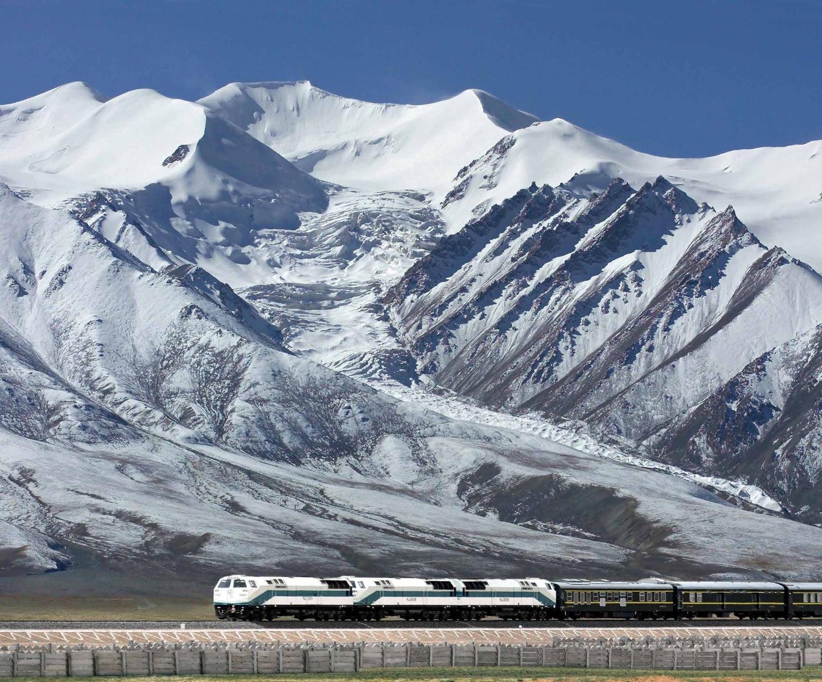 Tren del Ferrocarril Qinghai-Tíbet frente a montañas nevadas